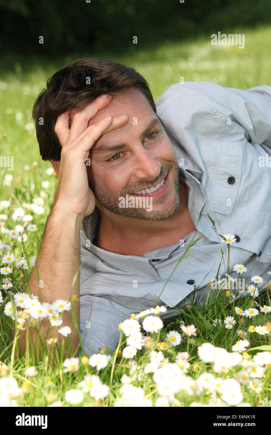 Happy man laid in a field Stock Photo - Alamy