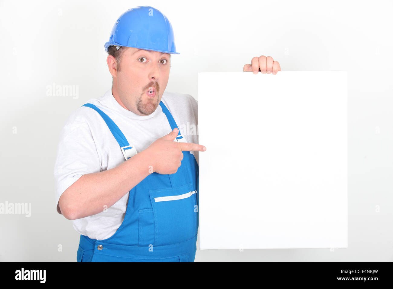 Surprised tradesman holding a blank sign Stock Photo