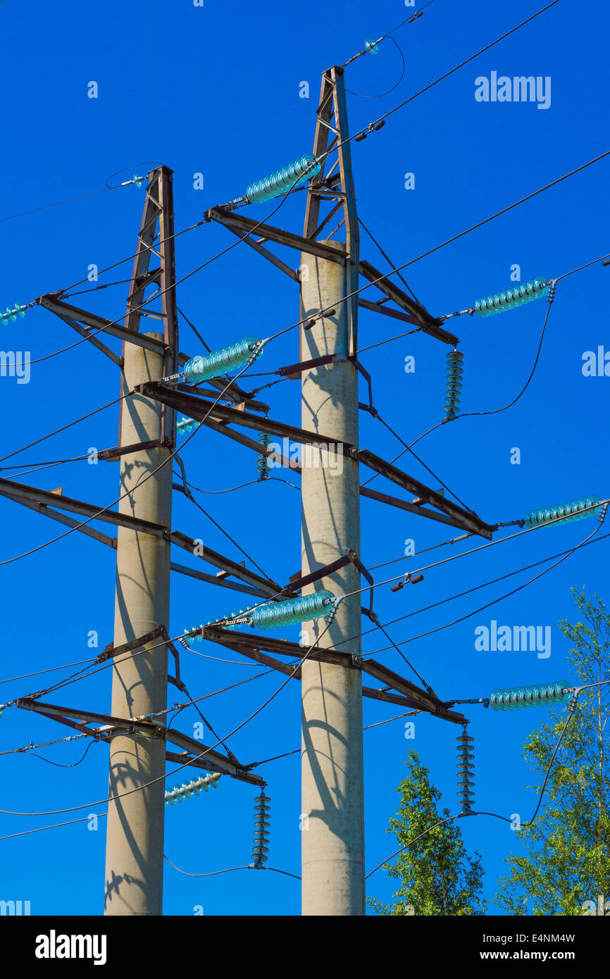 Couple of high voltage power pylons against blue sky Stock Photo - Alamy