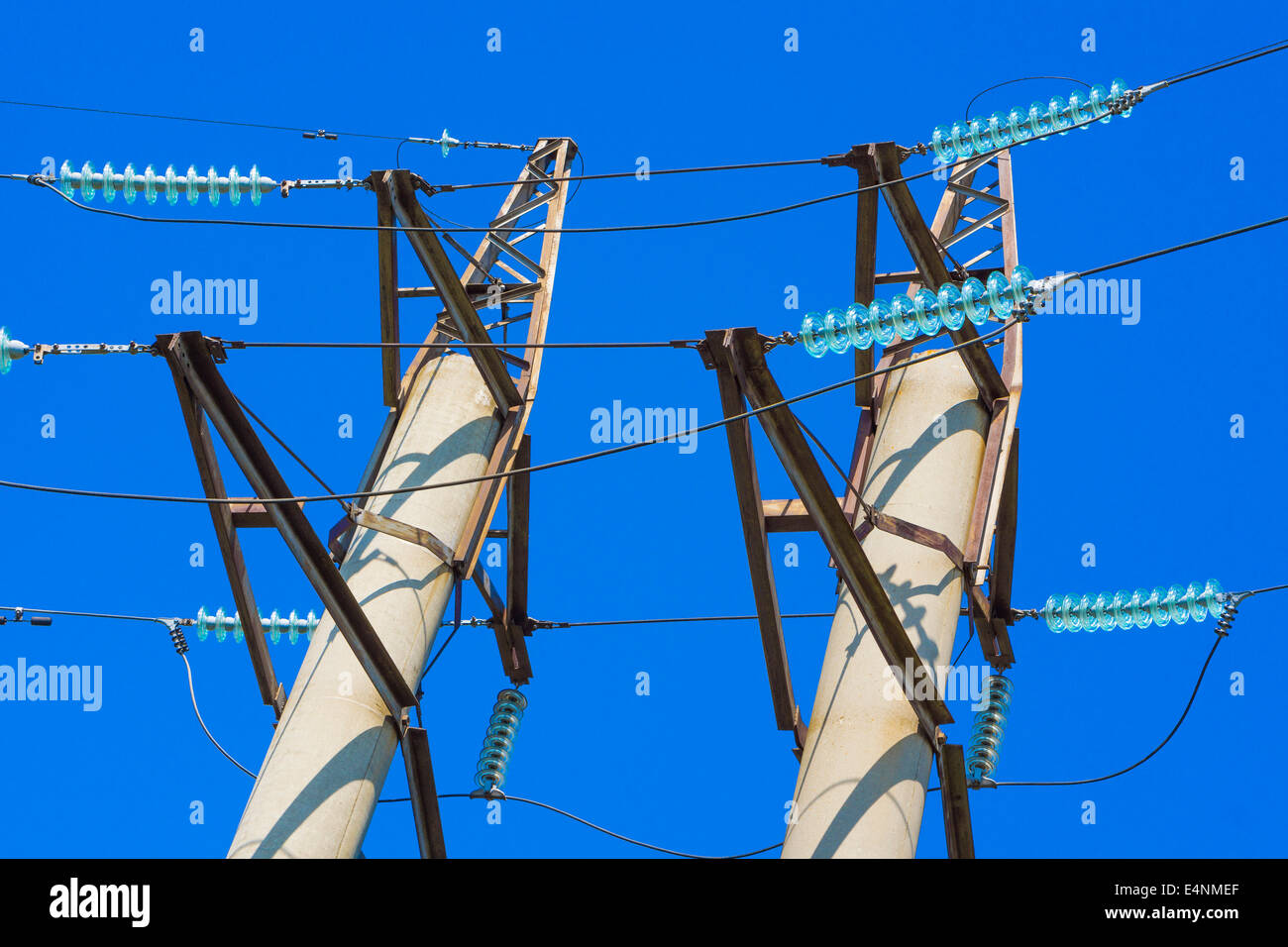 Top of high voltage power pylons against blue sky Stock Photo - Alamy