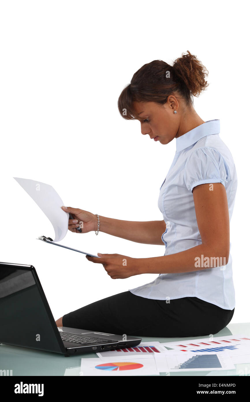 Woman perusing documents at her desk Stock Photo - Alamy