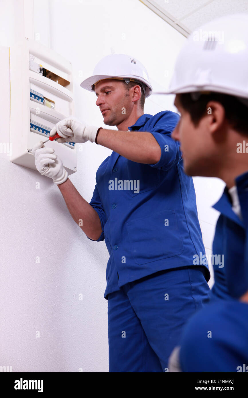 Tradesman repairing a distribution board Stock Photo