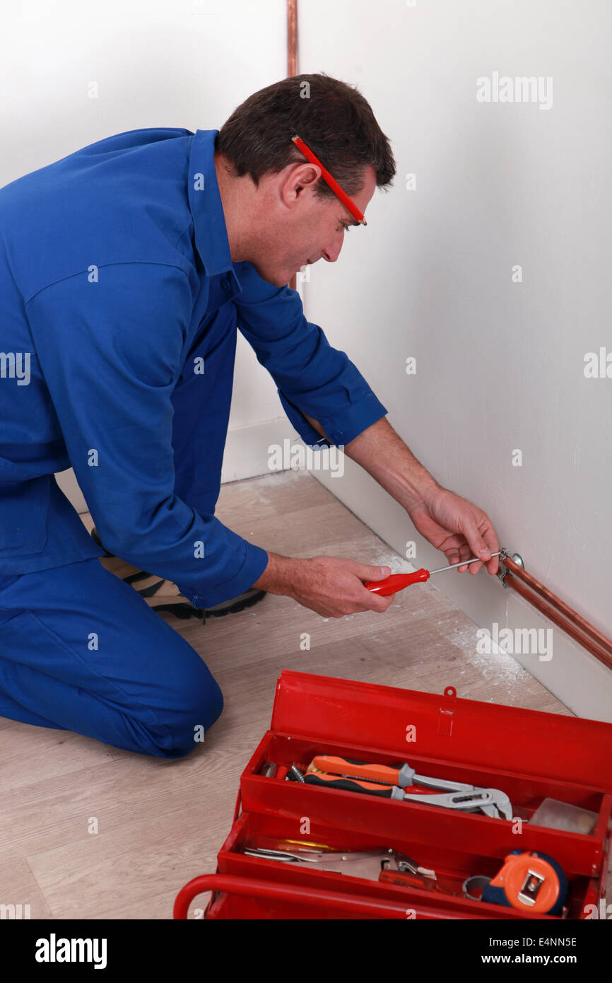labourer fixing pipe Stock Photo Alamy