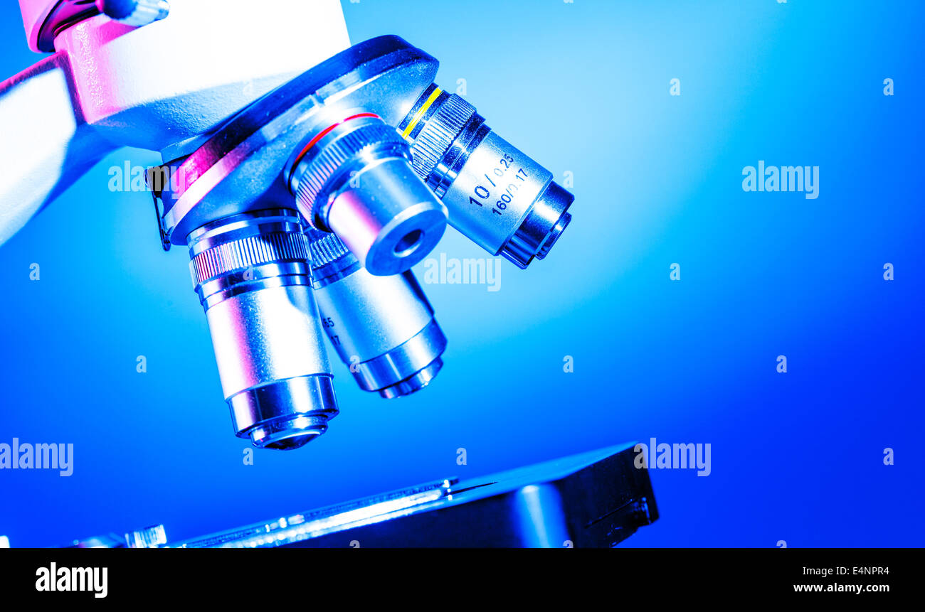 Scientific microscope lens on blue background, A microscope is an