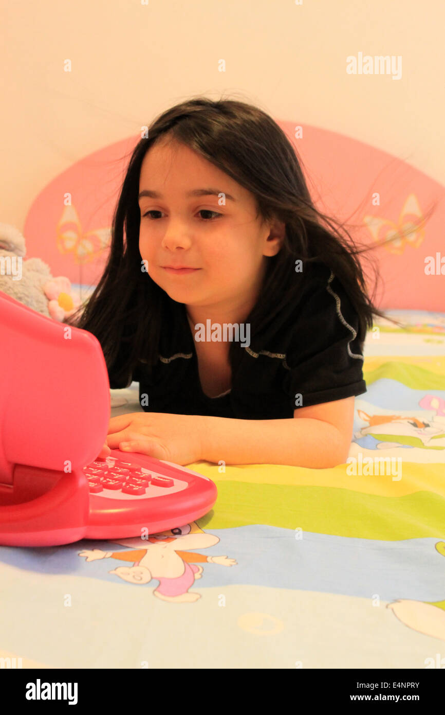 Child girl playing with laptop toy Stock Photo