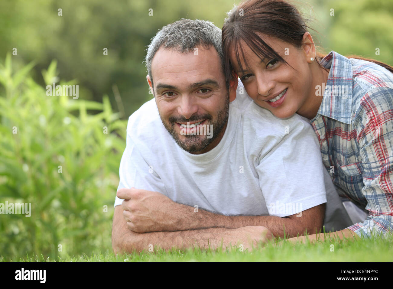 Couple lying in the grass Stock Photo - Alamy