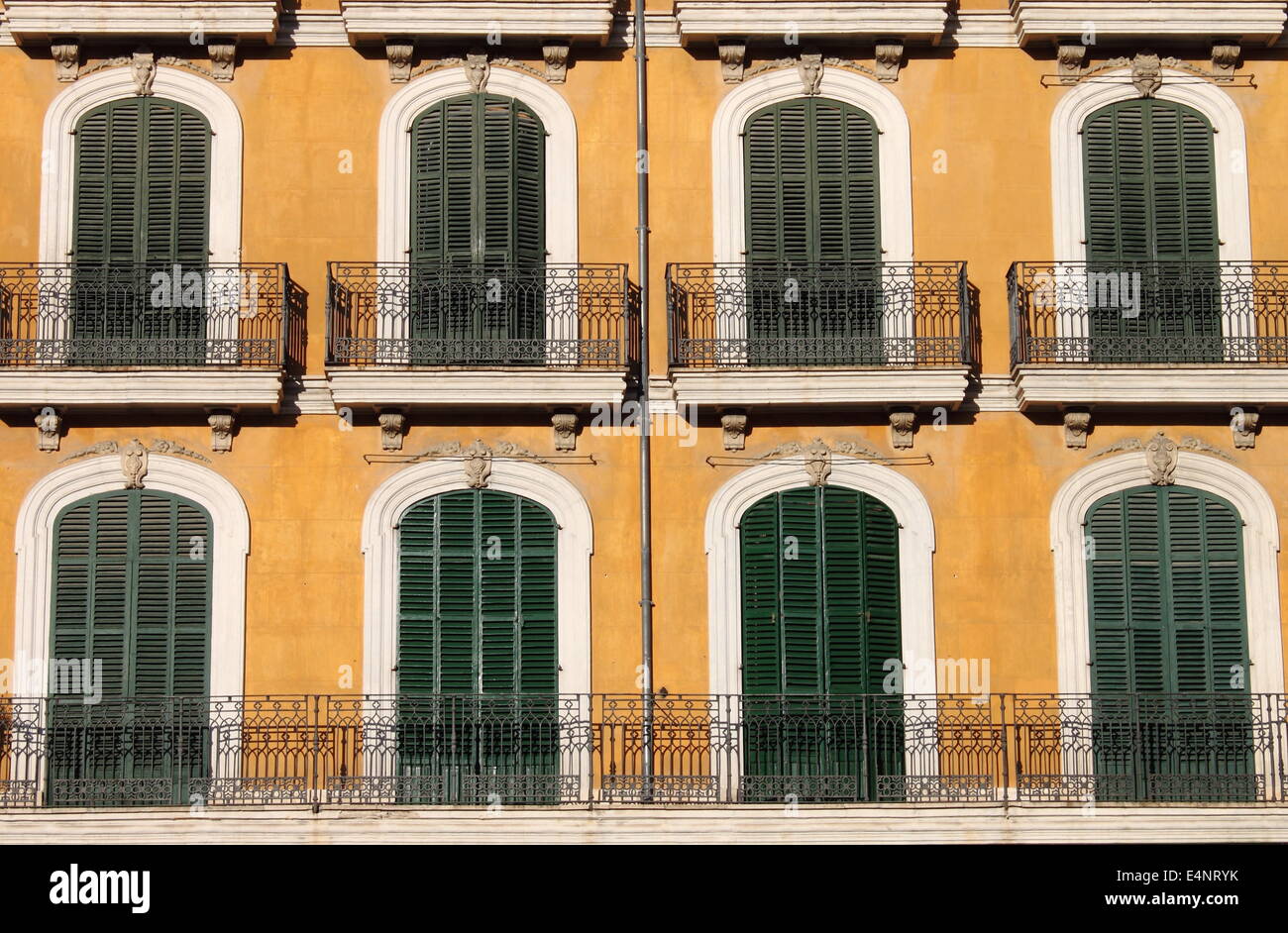Arched windows with closed shutters and balconies Stock Photo