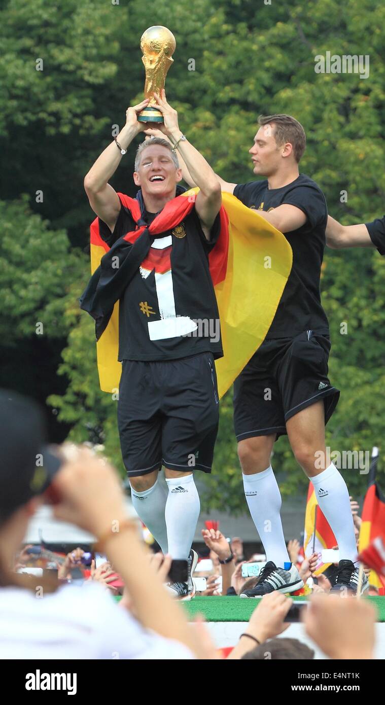 Germany's Bastian Schweinsteiger (L) and Manuel Neuer raise the World Cup trophy in their hands and cheers during the welcome reception for Germany's national soccer team in front of the Brandenburg Gate, Berlin, Germany, 15 July 2014. The German team won the Brazil 2014 FIFA Soccer World Cup final against Argentina by 1-0 on 13 July 2014, winning the world cup title for the fourth time after 1954, 1974 and 1990. Photo: Jens Wolf/dpa/Alamy Live News Stock Photo