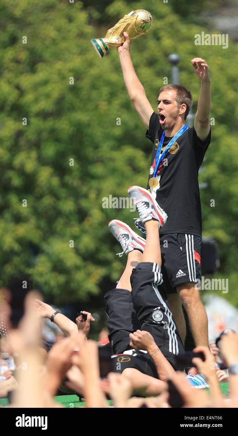 Berlin, Germany. 15th July, 2014. Germany's Philipp Lahm stands on stage with the World Cup trophy in his hands as he cheers and celebrates during the welcome reception for Germany's national soccer team in front of the Brandenburg Gate, Berlin, Germany, 15 July 2014. The German team won the Brazil 2014 FIFA Soccer World Cup final against Argentina by 1-0 on 13 July 2014, winning the world cup title for the fourth time after 1954, 1974 and 1990. Photo: Jens Wolf/dpa/Alamy Live News Stock Photo