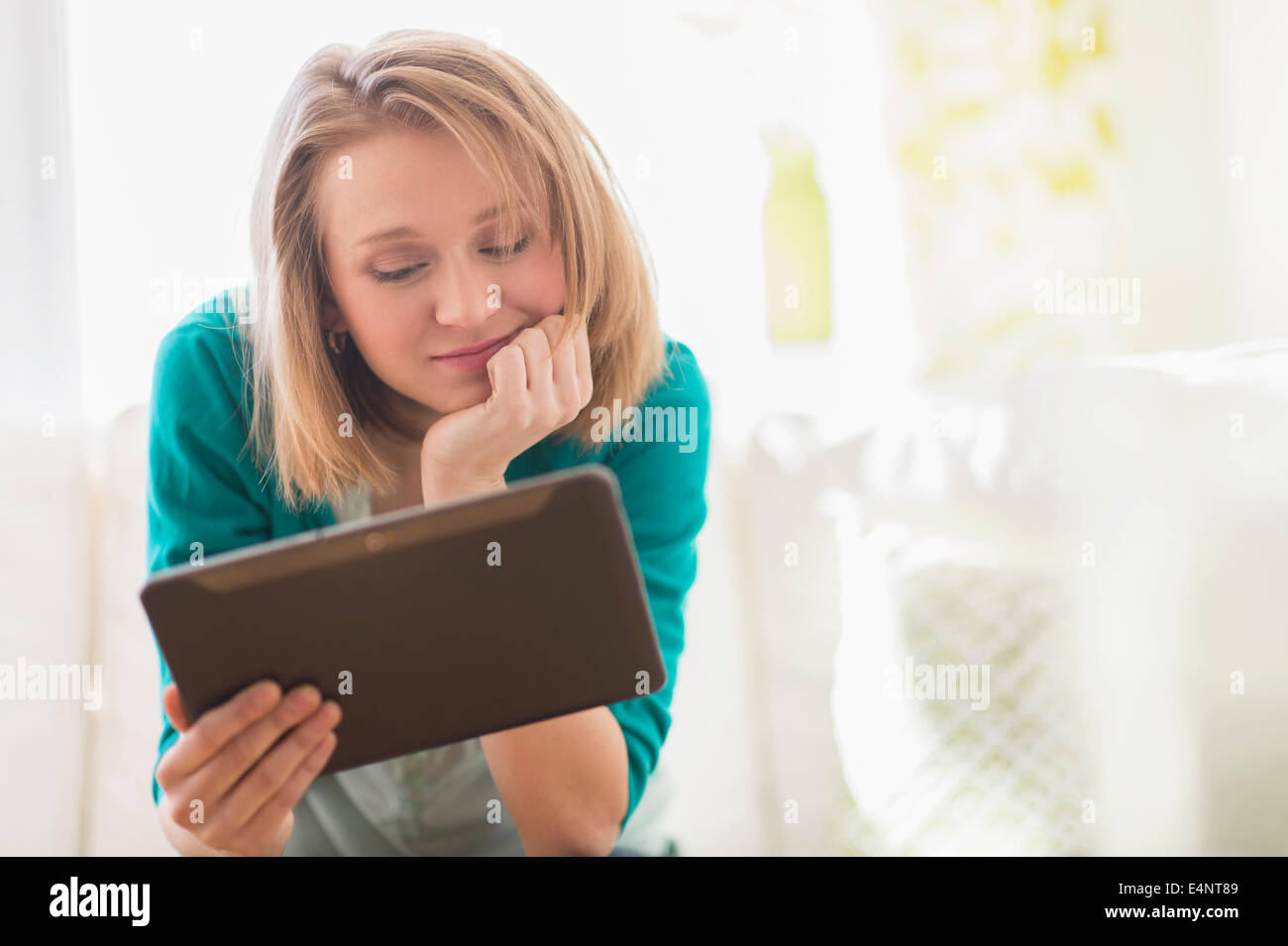 Portrait of woman on sofa using digital tablet Stock Photo - Alamy