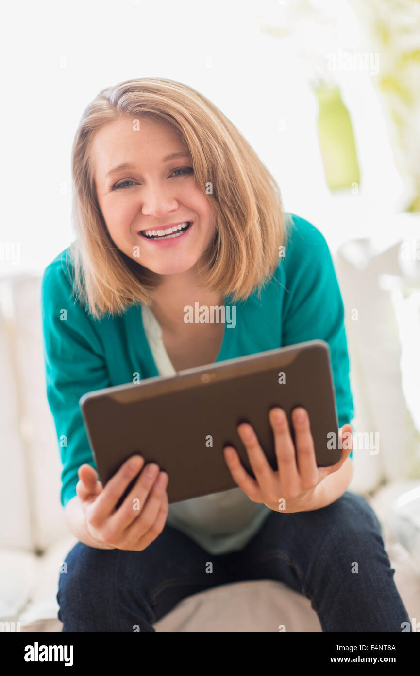 Portrait of woman on sofa holding digital tablet Stock Photo - Alamy
