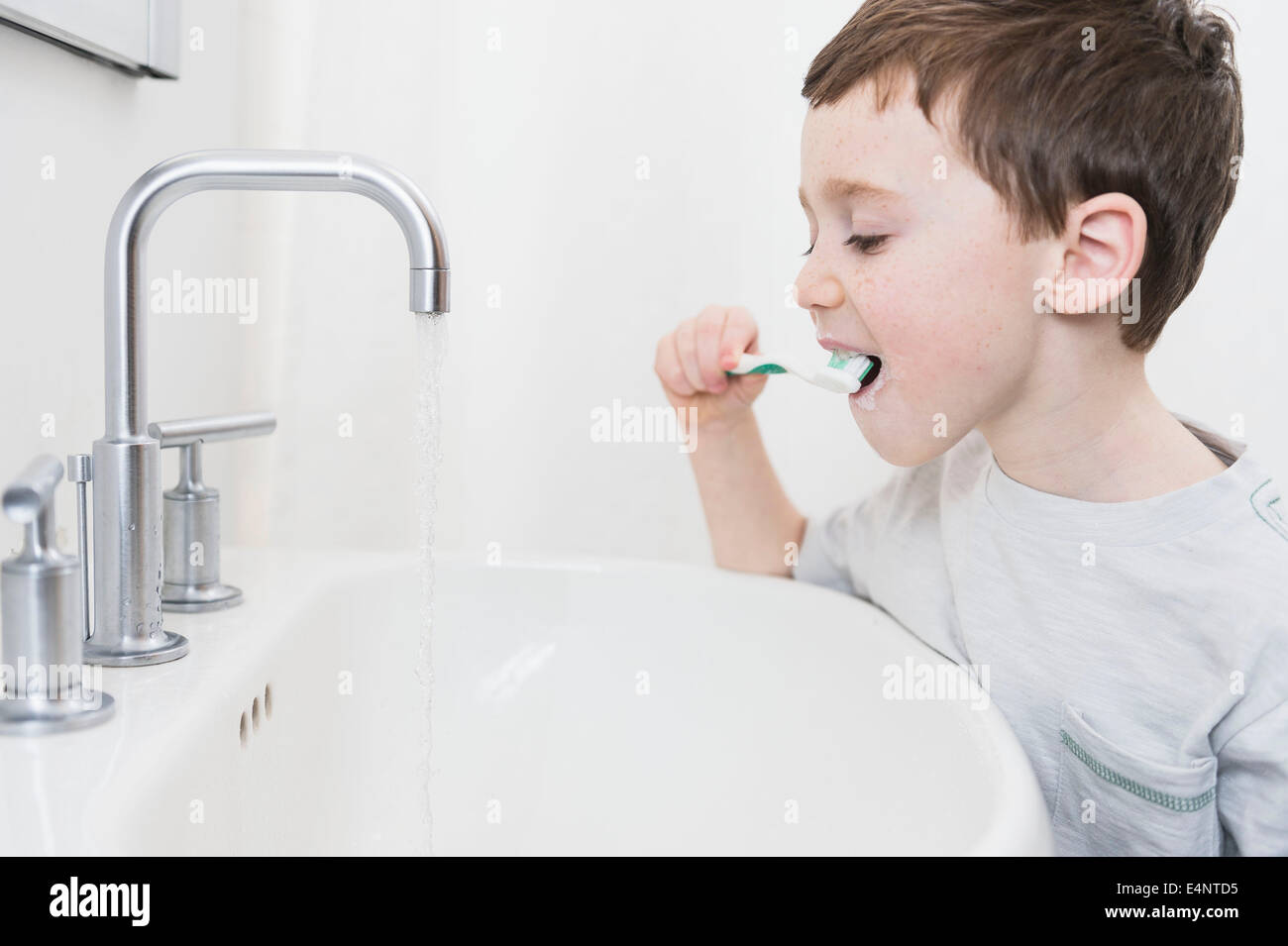Boy (6-7) brushing teeth Stock Photo