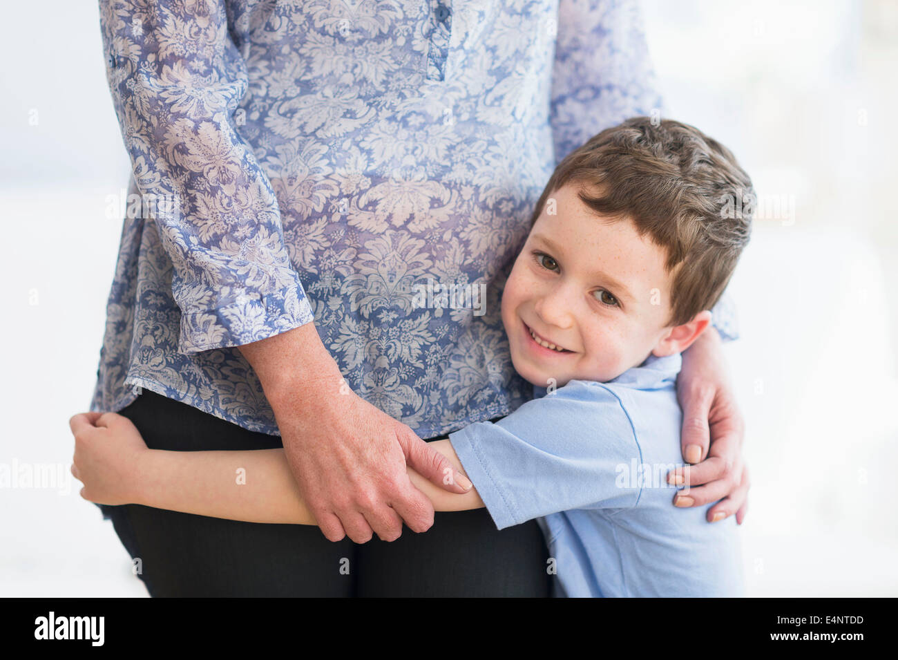 Boy (6-7) embracing mother Stock Photo