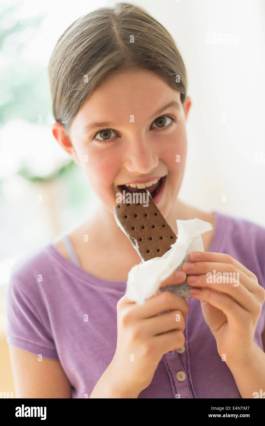 Girl (10-11) eating ice cream sandwich Stock Photo