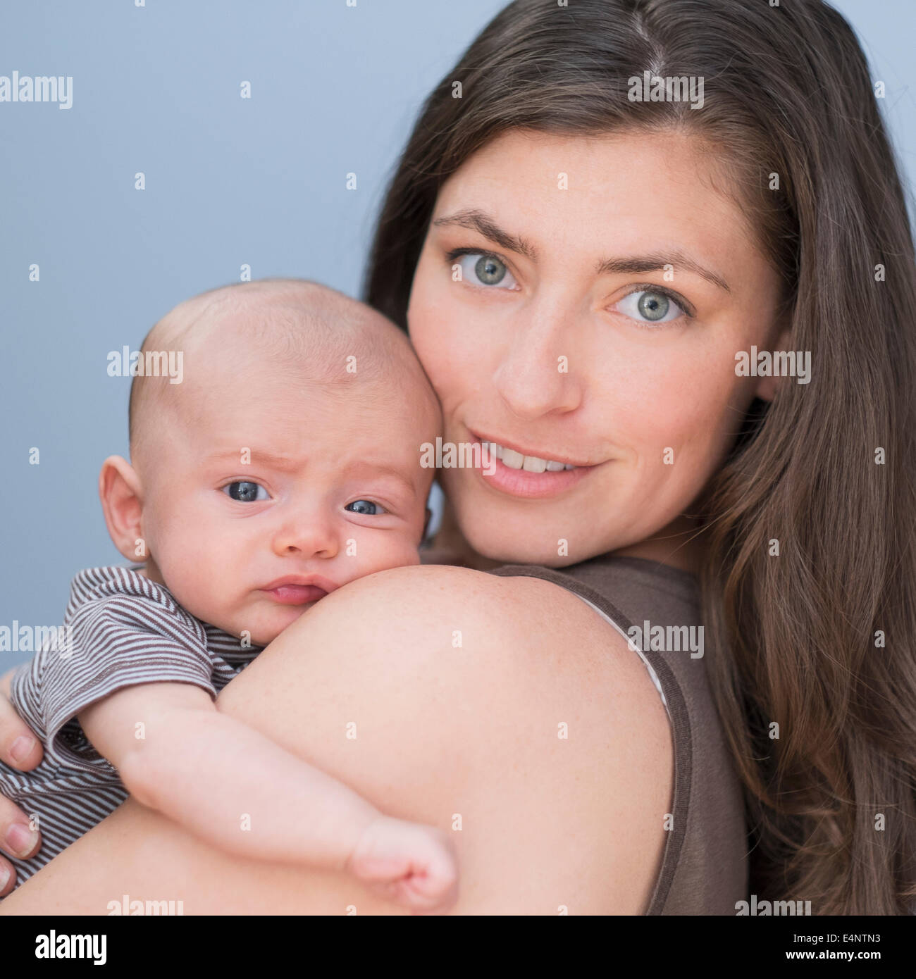 Portrait of smiling mother holding baby boy (2-5 months) on her arm Stock Photo