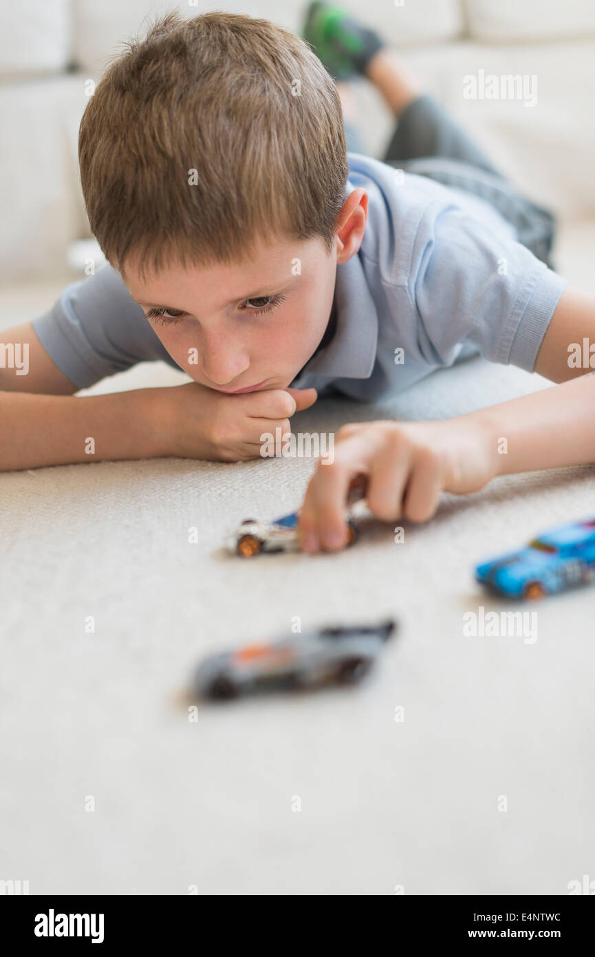 Boy (8-9) playing with toy cars Stock Photo