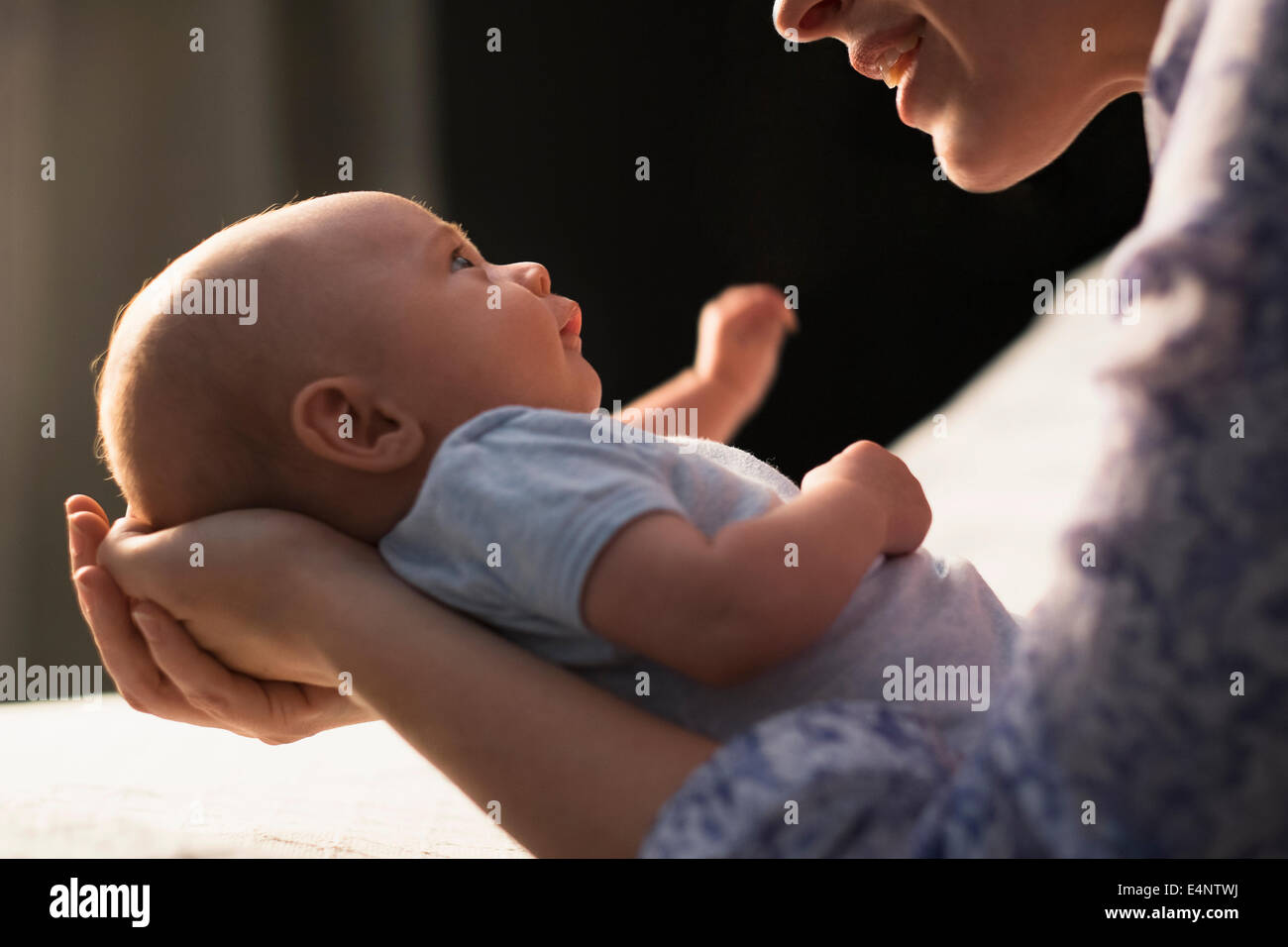 Mother holding baby boy (2-5 months) in bedroom Stock Photo