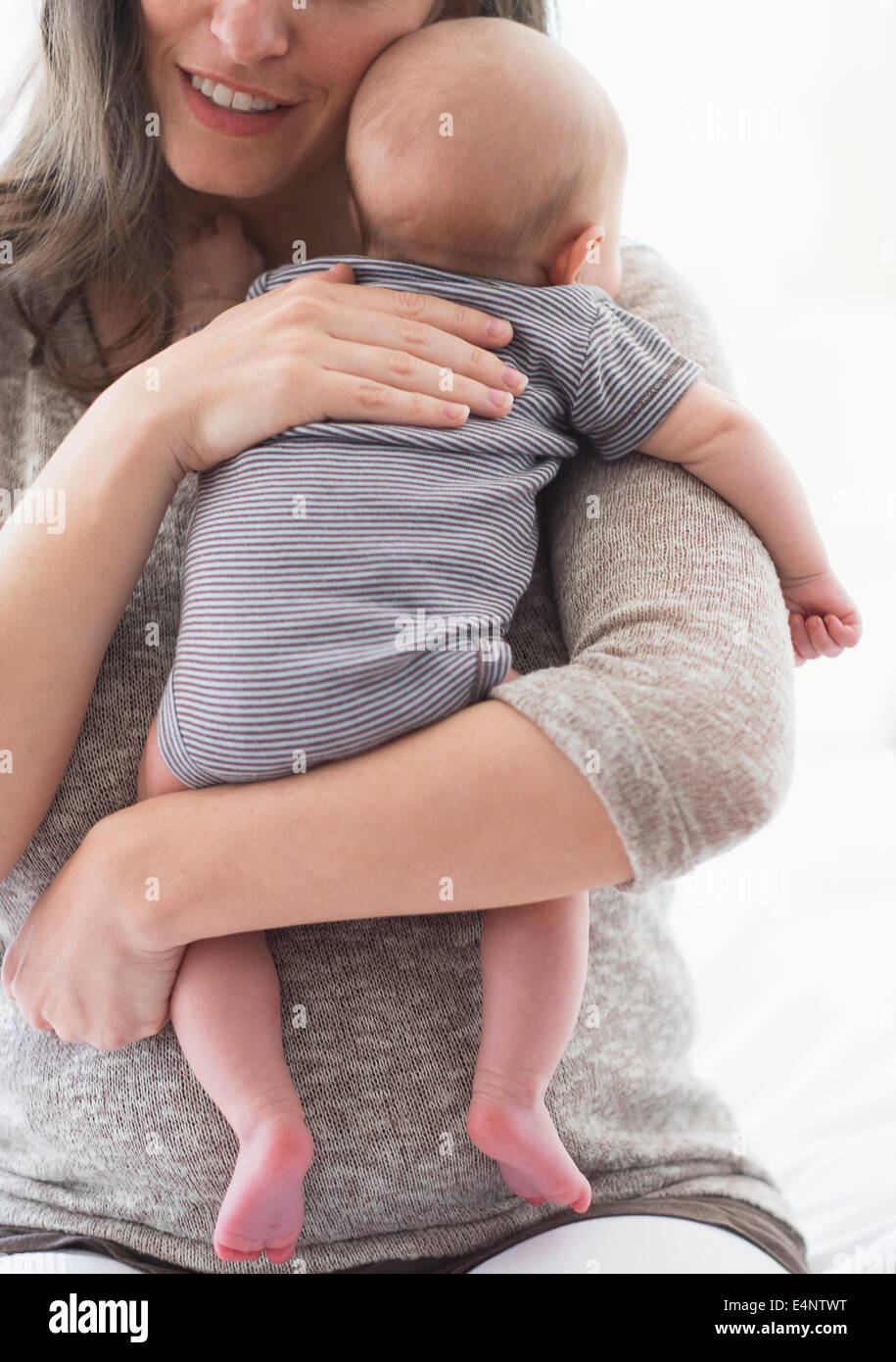 Mother holding baby boy (2-5 months) on her arm Stock Photo