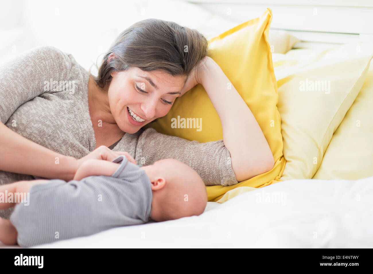 Mother with baby boy (2-5 months) lying on bed Stock Photo