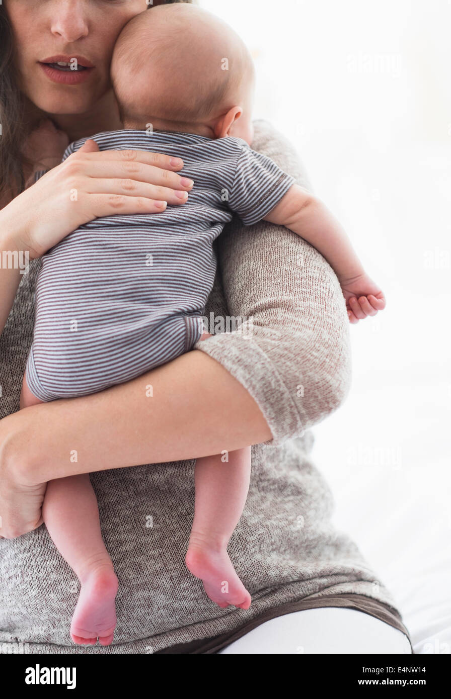 Mother holding baby boy (2-5 months) on her arm Stock Photo