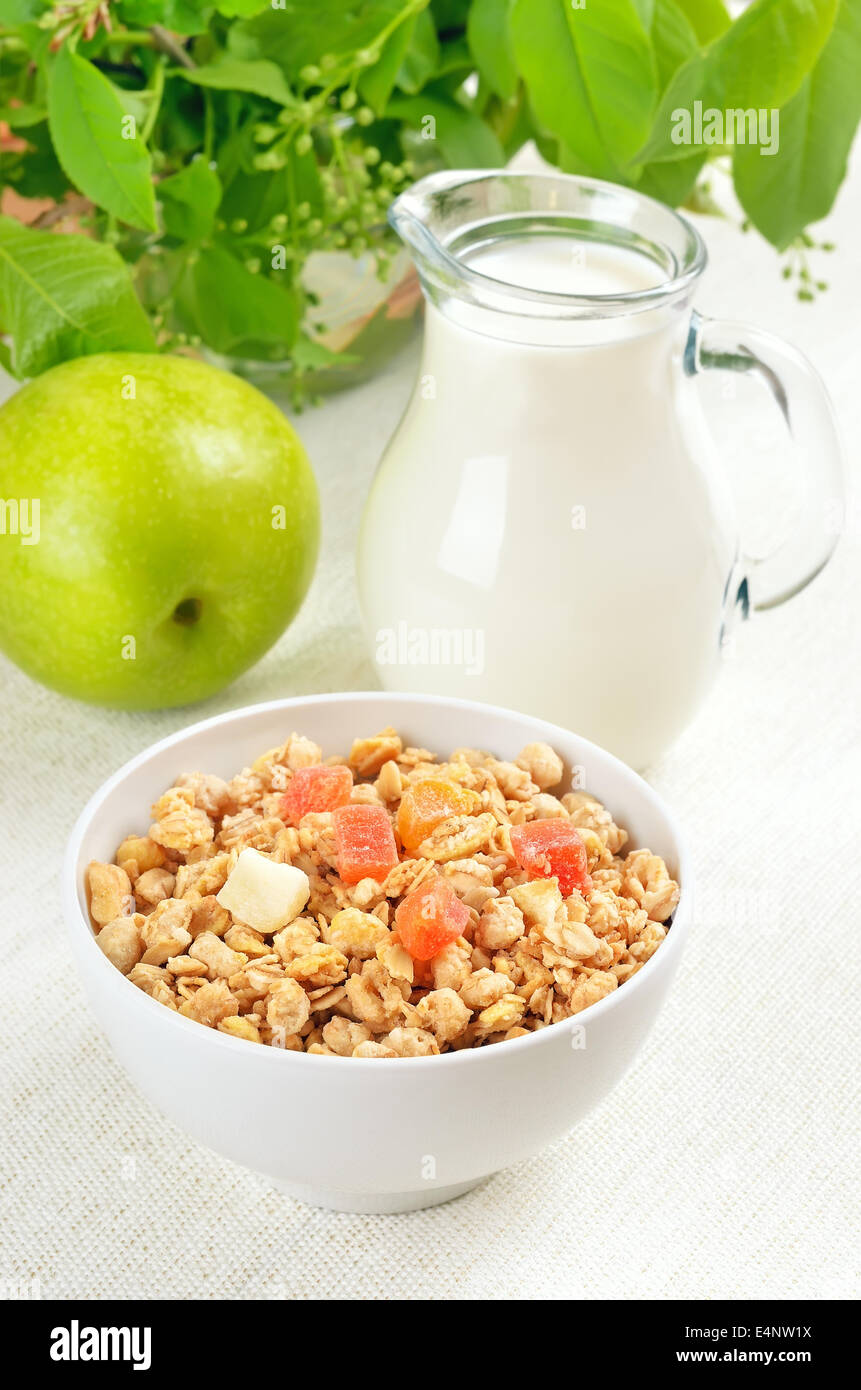 Muesli with dried fruits, jug of milk and apple Stock Photo Alamy