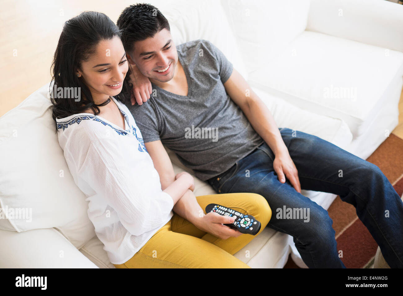 Young couple watching tv on sofa Stock Photo