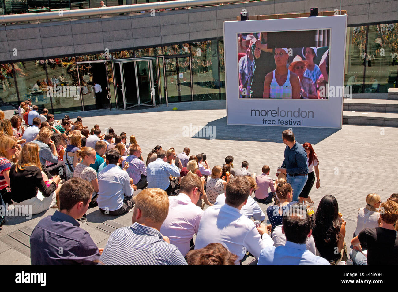 Wimbledon fans gather to watch live tennis on a giant LCD screen as part of the More London free festival,Centre Court,London,UK Stock Photo