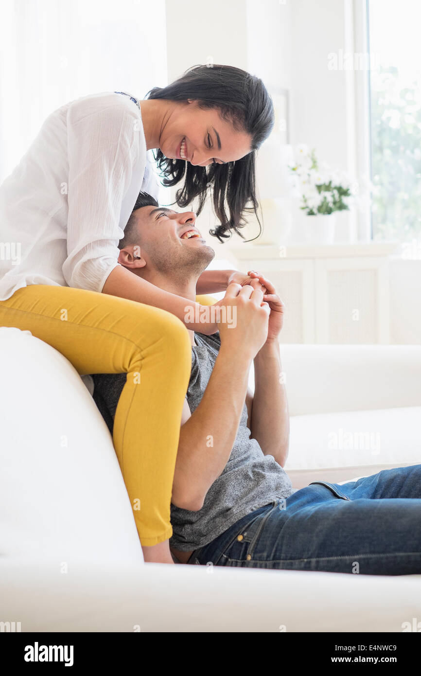 Happy young couple playing on sofa Stock Photo