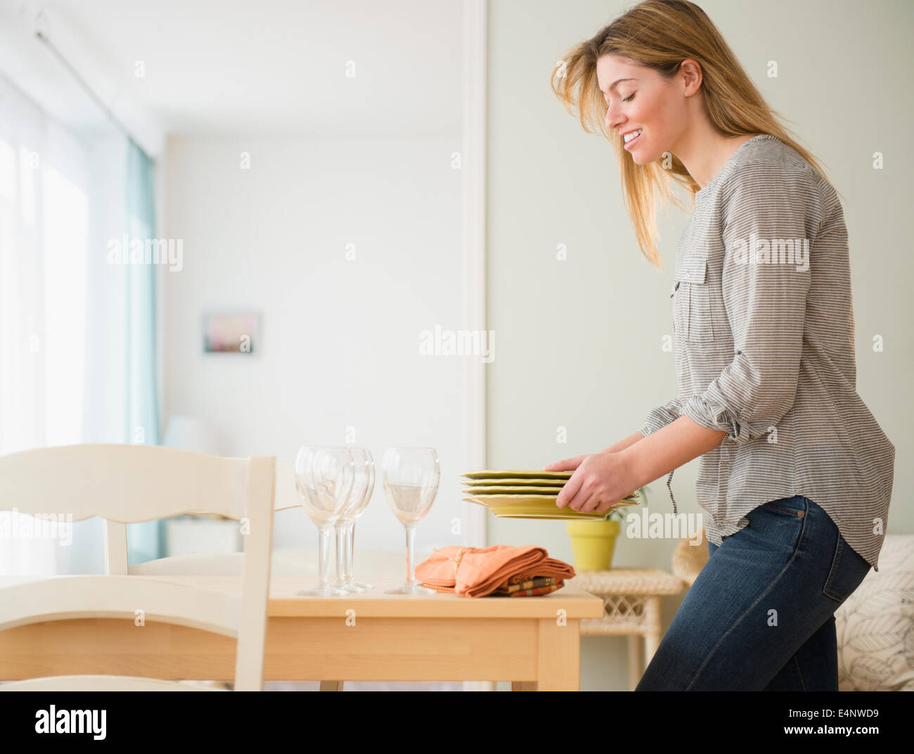 Young woman setting table Stock Photo