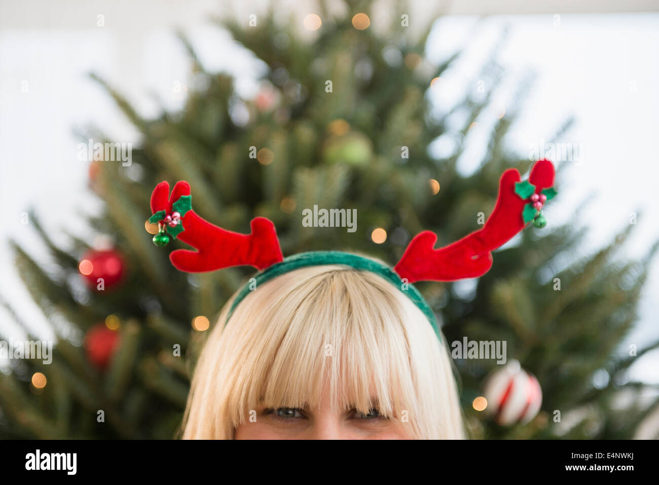 Blond woman wearing reindeer headband Stock Photo