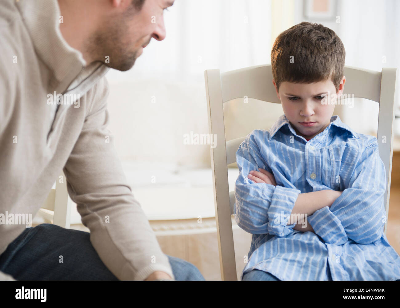 Father looking at displeased son (8-9) Stock Photo