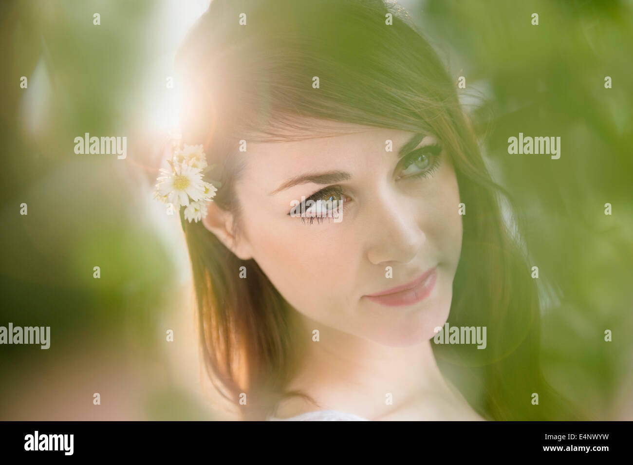 Portrait of young woman with daisies in hair Stock Photo Alamy