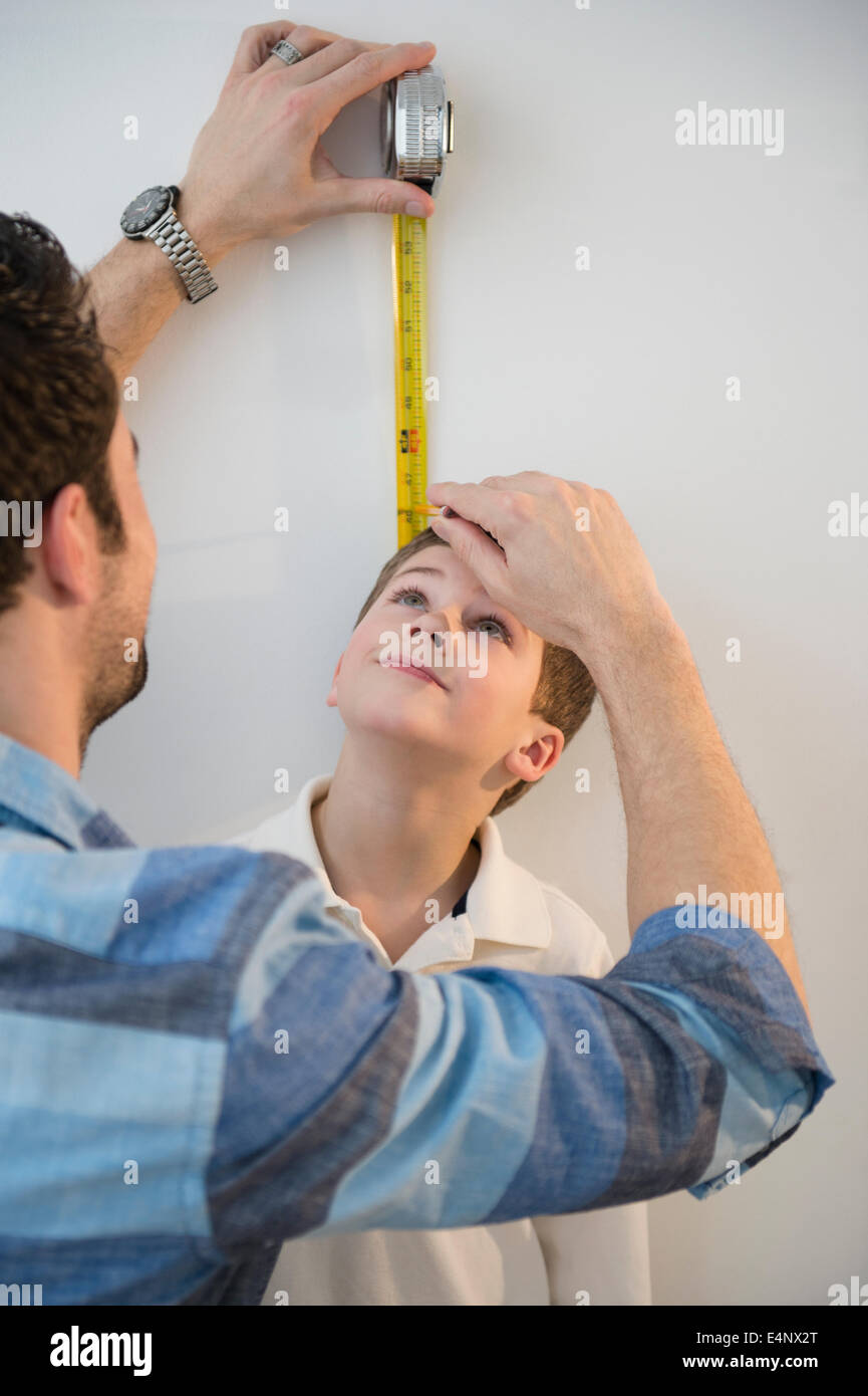 Father measuring height of son (8-9) Stock Photo