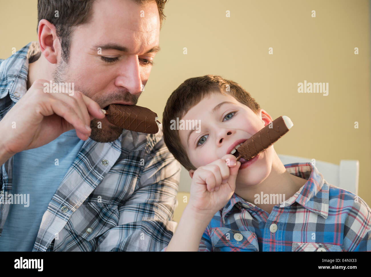 Father and son (8-9) eating ice creams Stock Photo