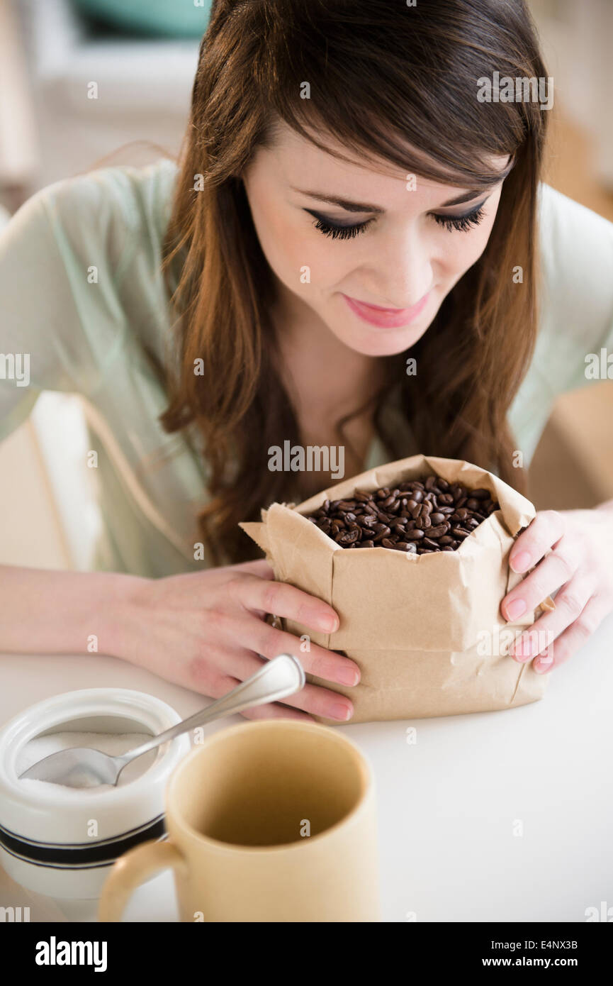 Young woman smelling coffee beans Stock Photo
