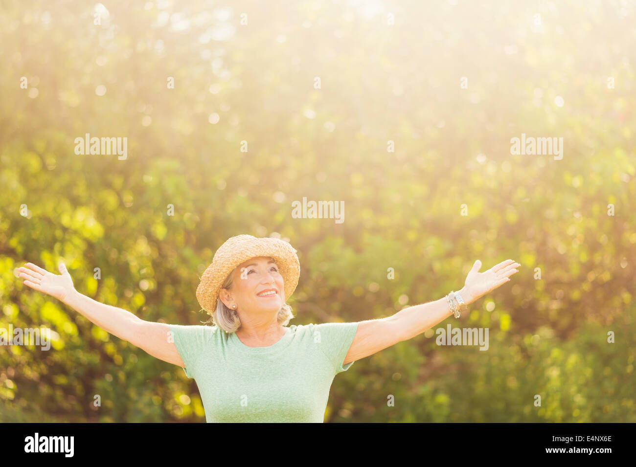 Senior woman in park with arms outstretched Stock Photo - Alamy