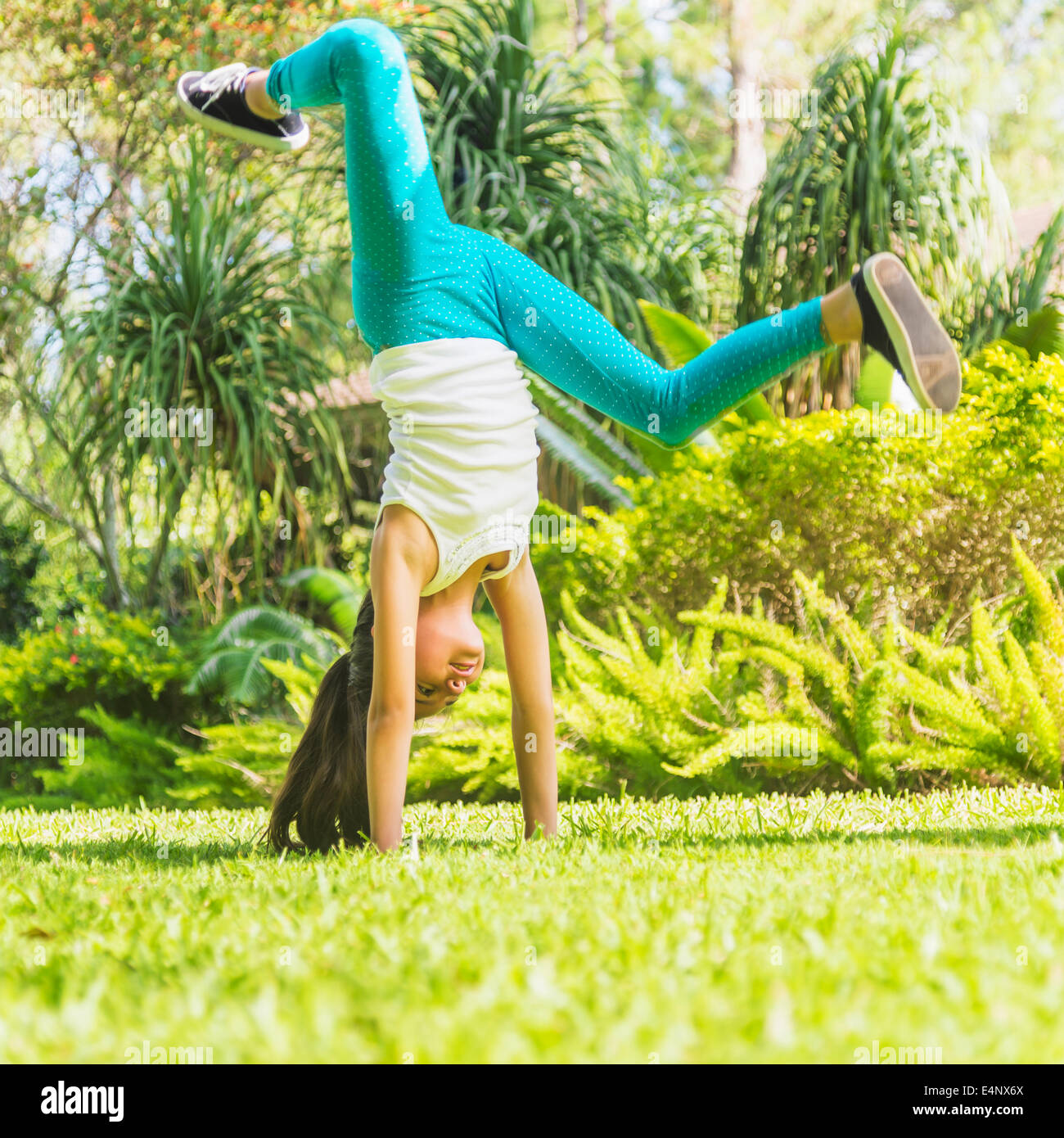 Girl (8-9) doing cartwheel on front yard Stock Photo
