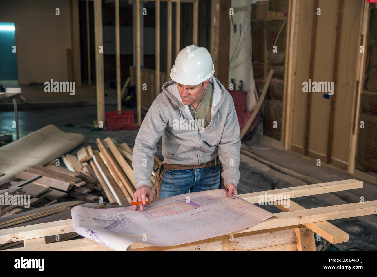 Engineer Inside Engineer examining blueprint inside new structure Stock Photo - Alamy