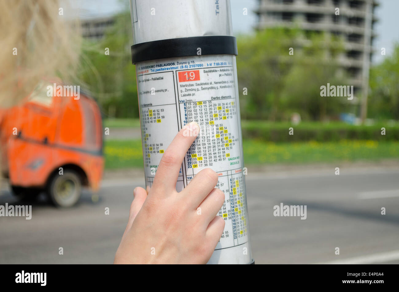 bus driving schedule under a glass hood and hand of woman Stock Photo