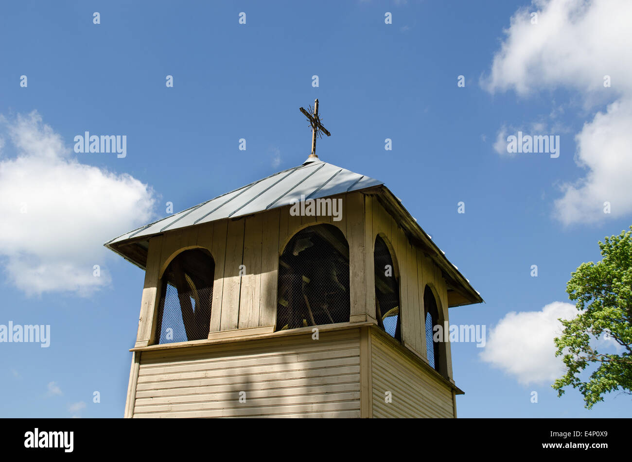 old wooden village church bell tower on blue spring sky background Stock Photo