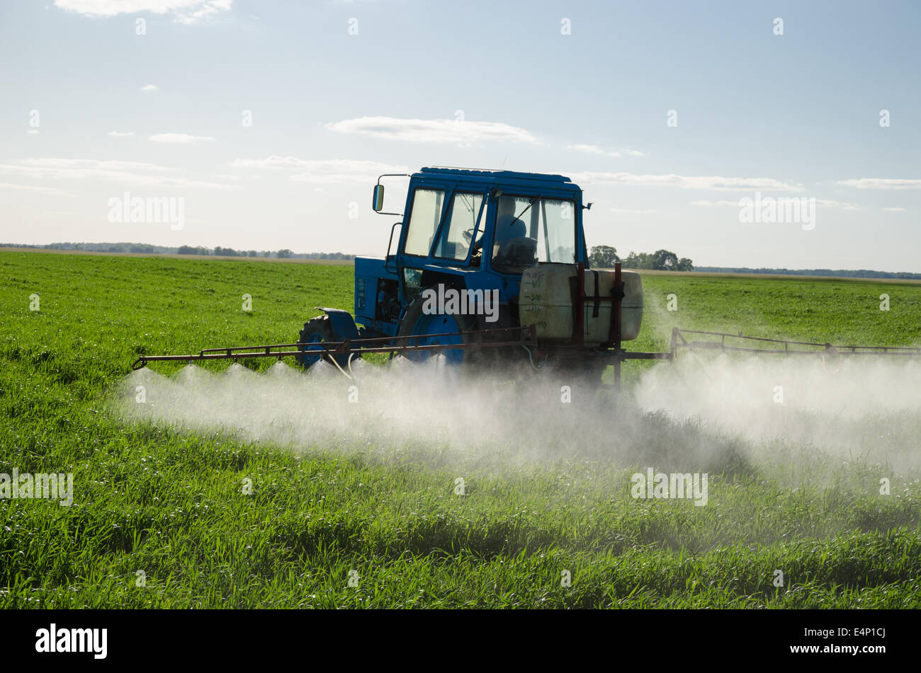 Tractor spray fertilize field with insecticide herbicide chemicals in