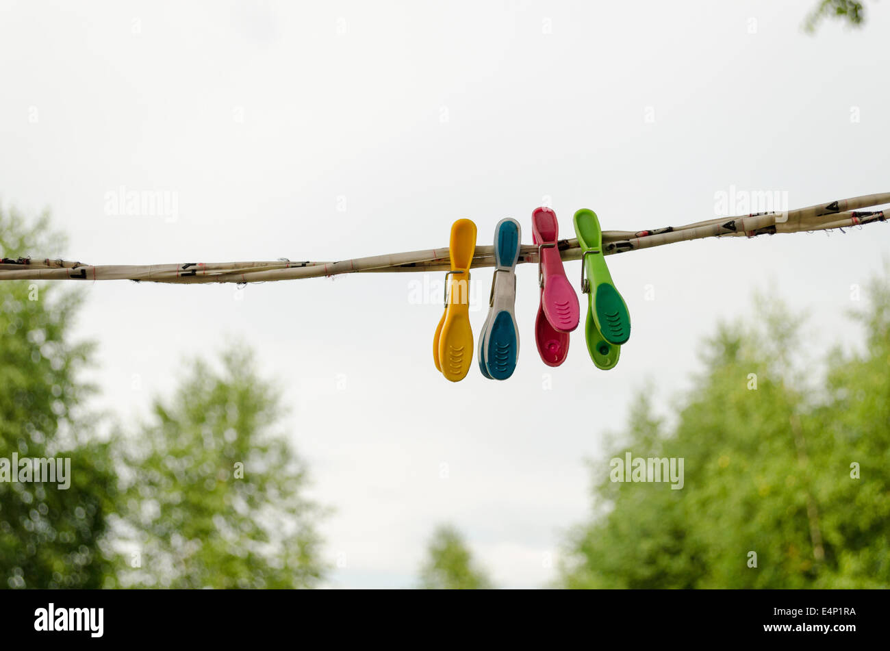 colorful shape clothes pins hanging on rope outdoor Stock Photo