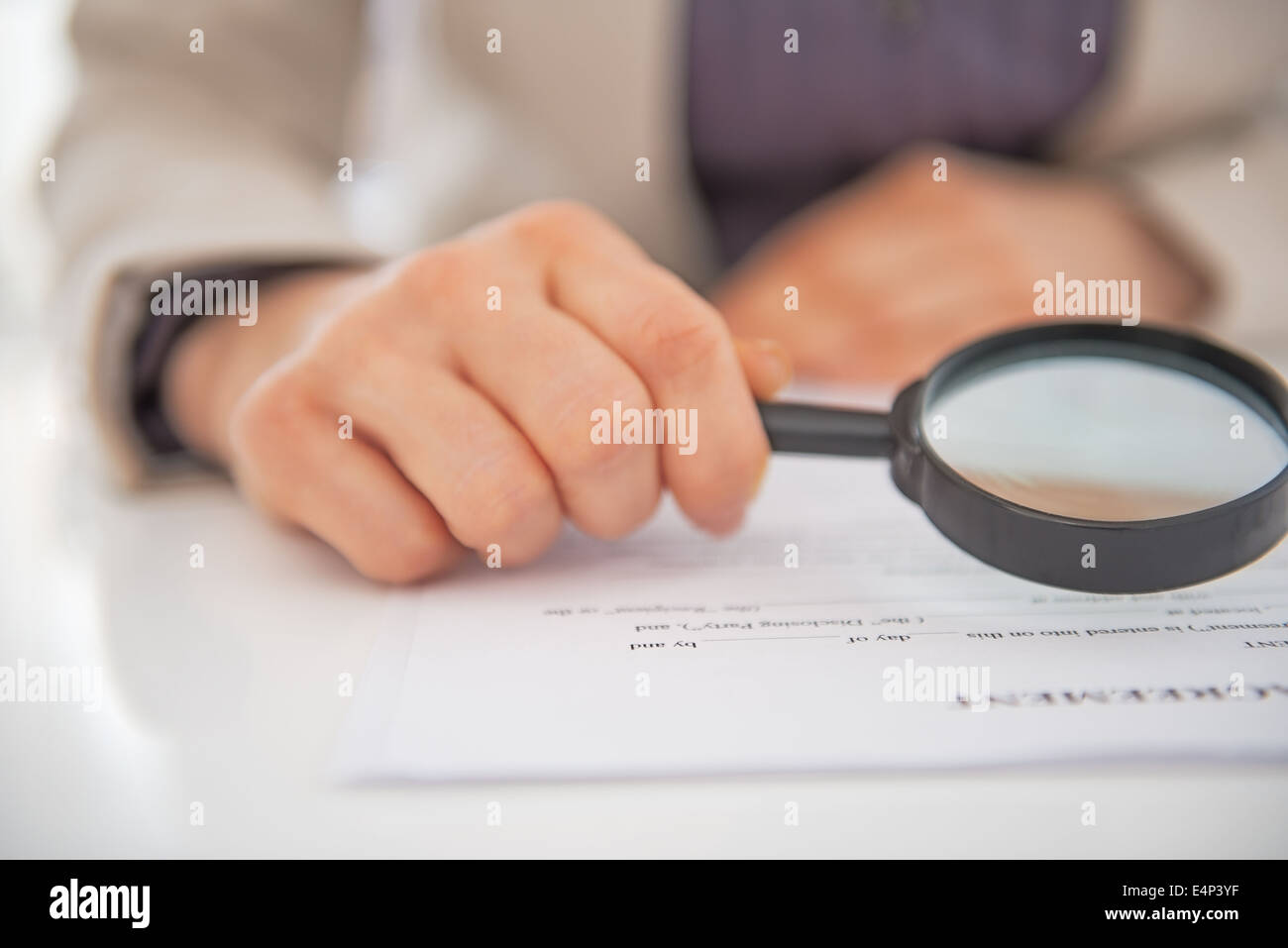 Closeup on business woman exploring document with magnifying lens Stock Photo