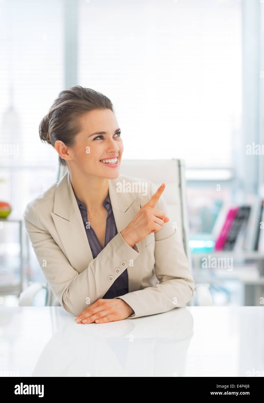 Happy business woman in office pointing on copy space Stock Photo - Alamy