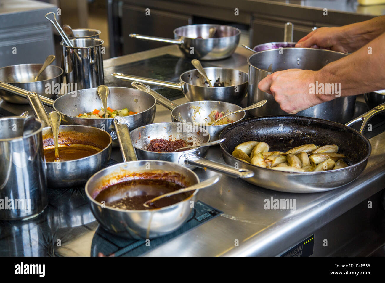 Kitchen of a restaurant, cooking pans and pots on an kitchen stove Stock Photo