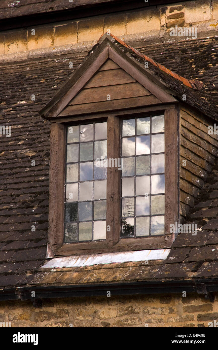 Old wooden dormer window in slate roof with leaded glass window panes showing reflections of sky, Oakham Castle, Rutland, UK Stock Photo