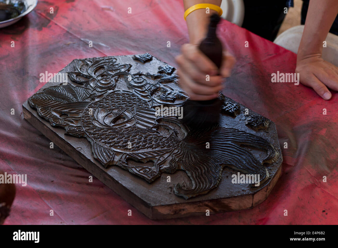 Man demonstrating Chinese woodblock printing at cultural festival USA