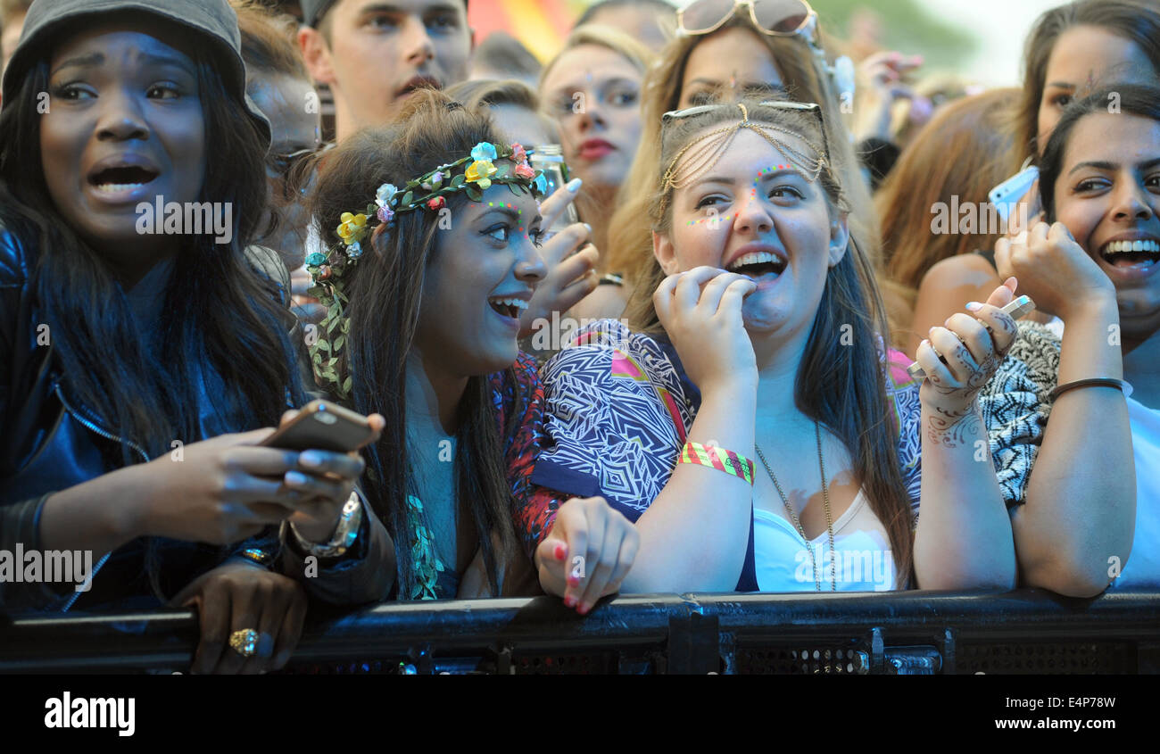 YOUNG PEOPLE ENJOYING WATCHING BANDS AT A OUTDOOR MUSIC FESTIVAL RE SUMMER FESTIVALS ROCK SINGERS TEENAGERS SOCIAL EVENTS UK Stock Photo