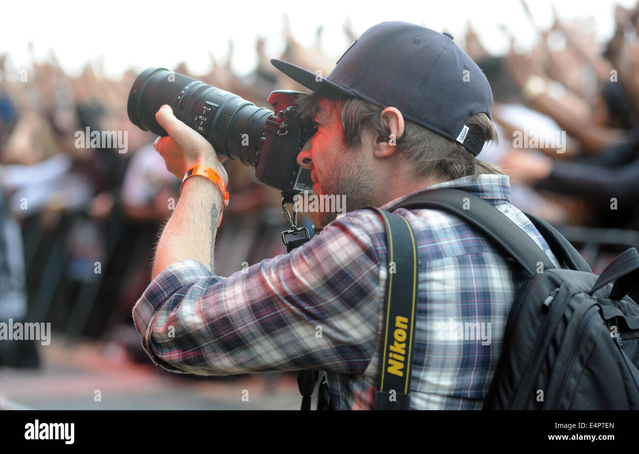 PHOTOGRAPHER WORKING AT A OUTDOOR MUSIC FESTIVAL RE SUMMER FESTIVALS ROCK SINGERS TEENAGERS SOCIAL EVENTS UK Stock Photo