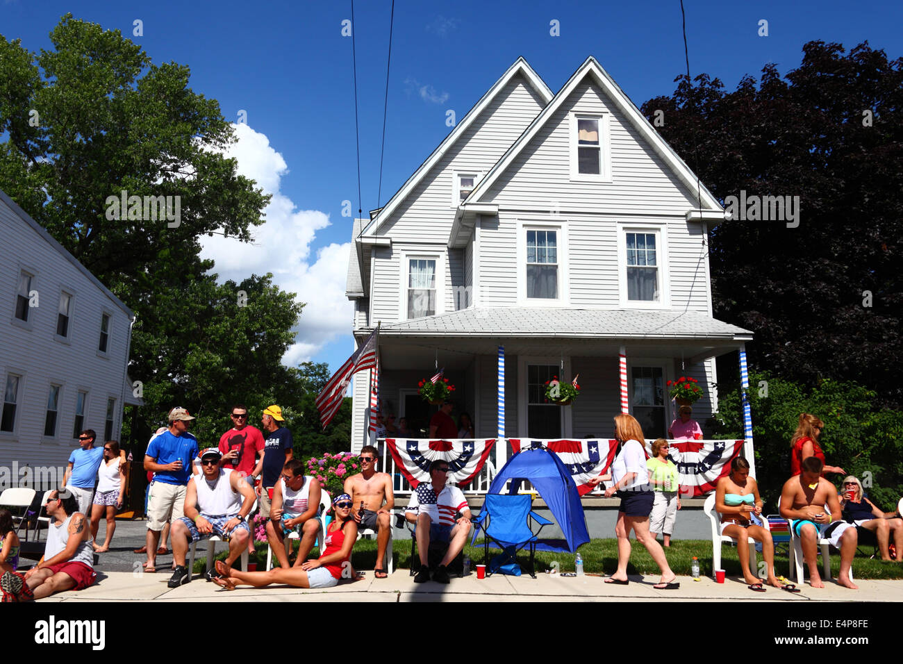 Spectators sitting outside house with decorated porch of house watching 4th of July Independence Day parades, Catonsville, Maryland, USA Stock Photo